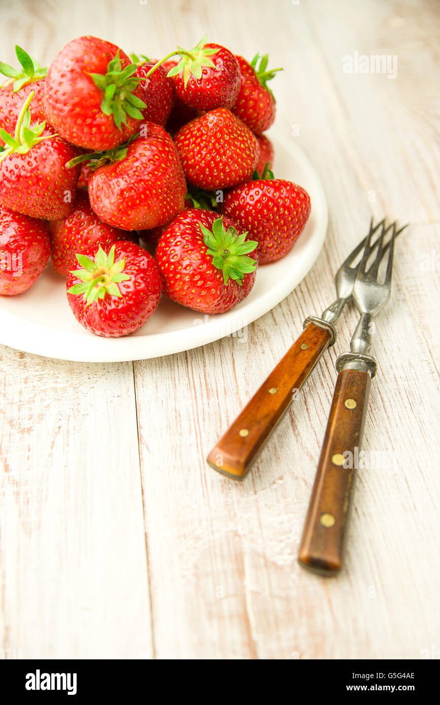 Ripe red strawberries on a white plate Stock Photo