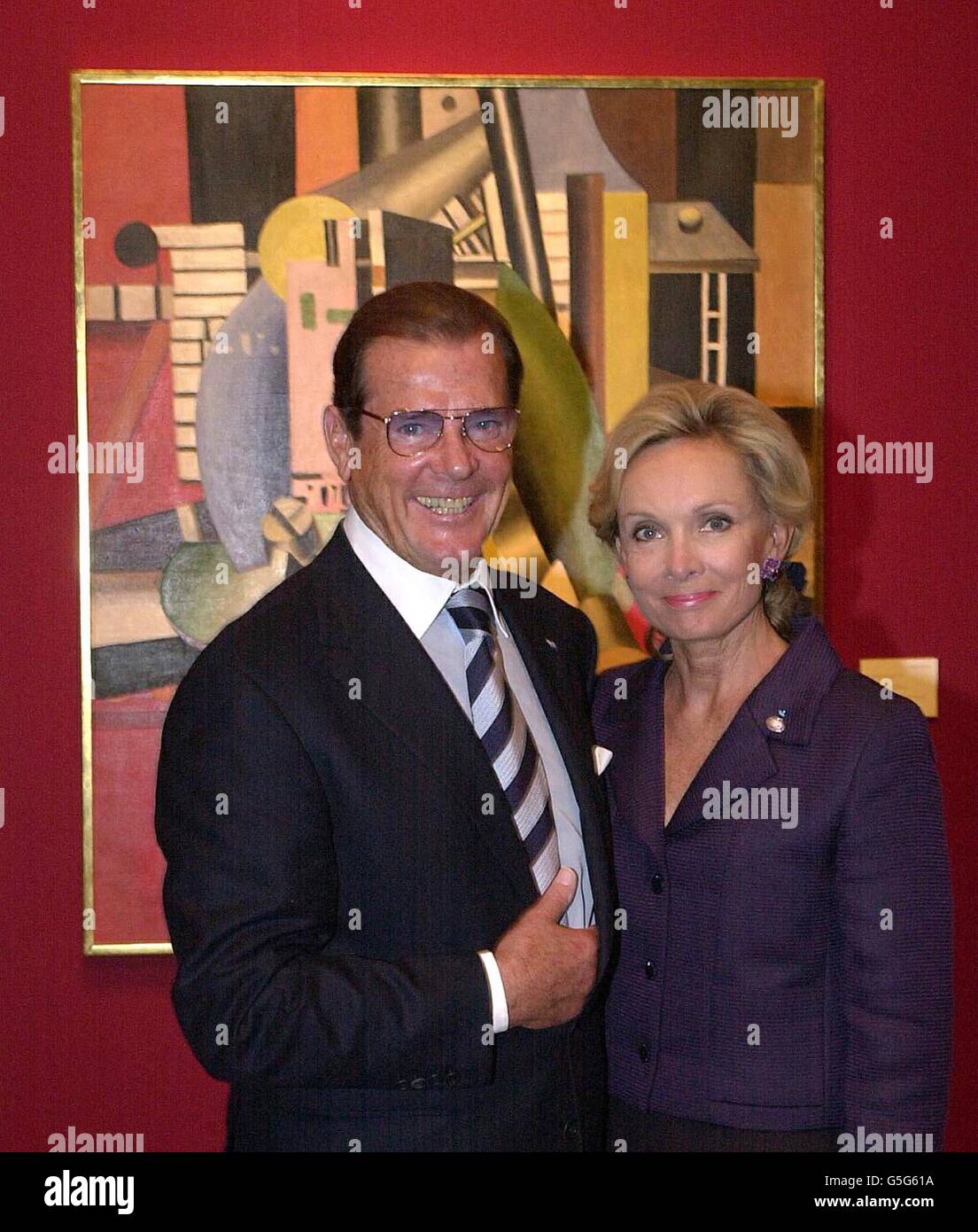 British actor Roger Moore, Goodwill Ambassador to UNICEF with his wife Kristina, standing by a painting by Fernand Leger, entitled Le Moteur at a press view at Christie's central London office, of impressionist and modern paintings from the collection of Rene Gaffe. * ... to be sold at Christie's New York to benefit UNICEF. Stock Photo