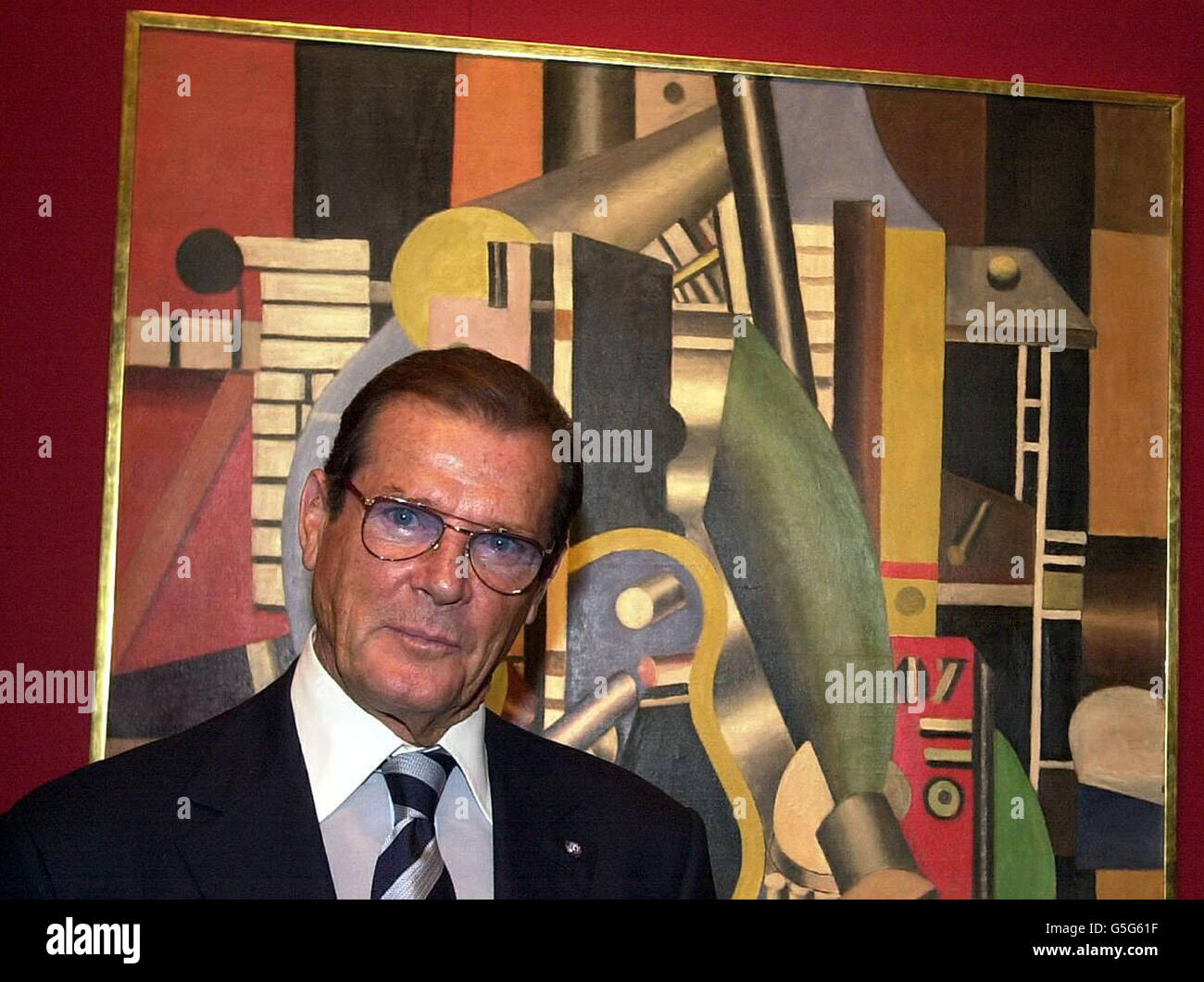 British actor Roger Moore, Goodwill Ambassador to UNICEF standing by a painting by Fernand Leger, entitled Le Moteur at a press view at Christie's central London office, of impressionist and modern paintings from the collection of Rene Gaffe. * to be sold at Christie's New York to benefit UNICEF. Stock Photo