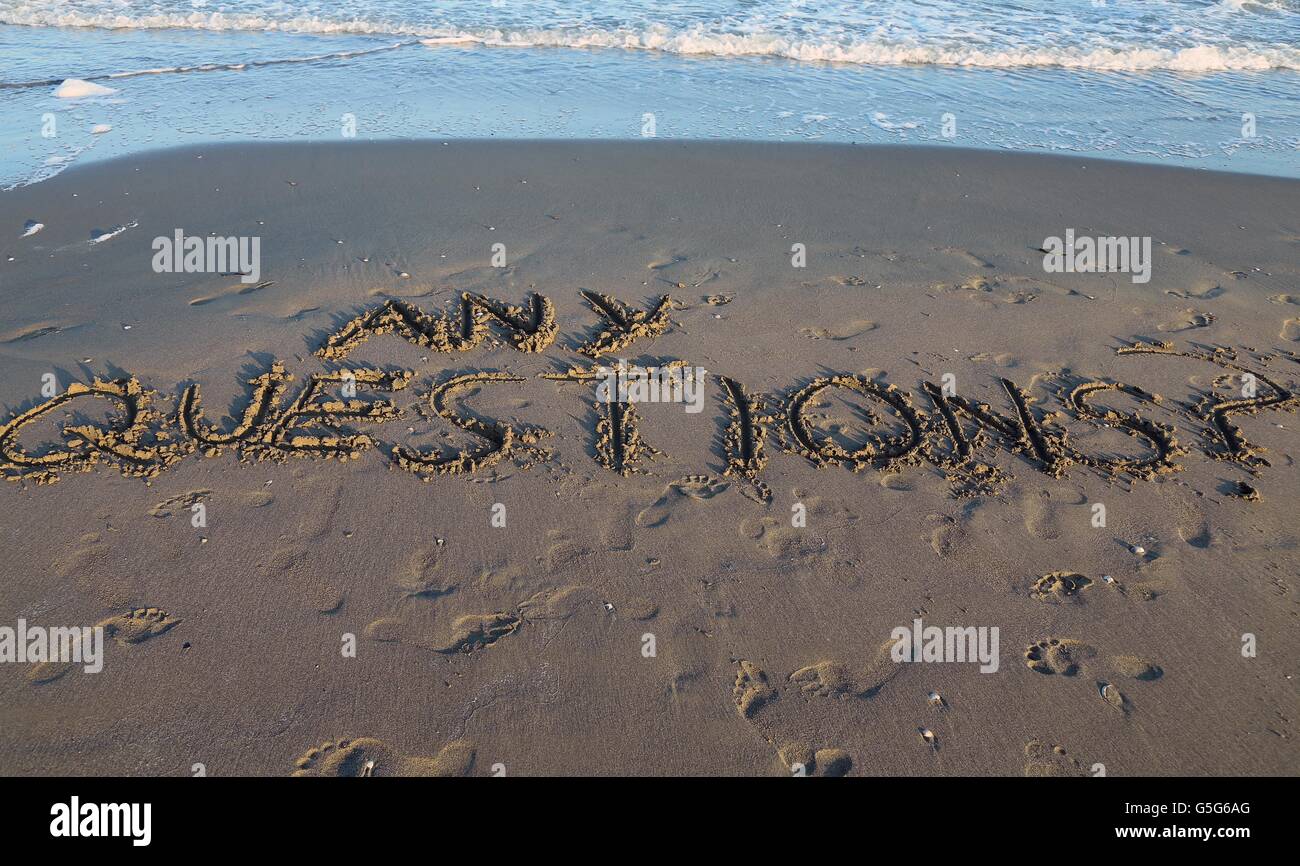 ANY QUESTIONS written on the sand Stock Photo