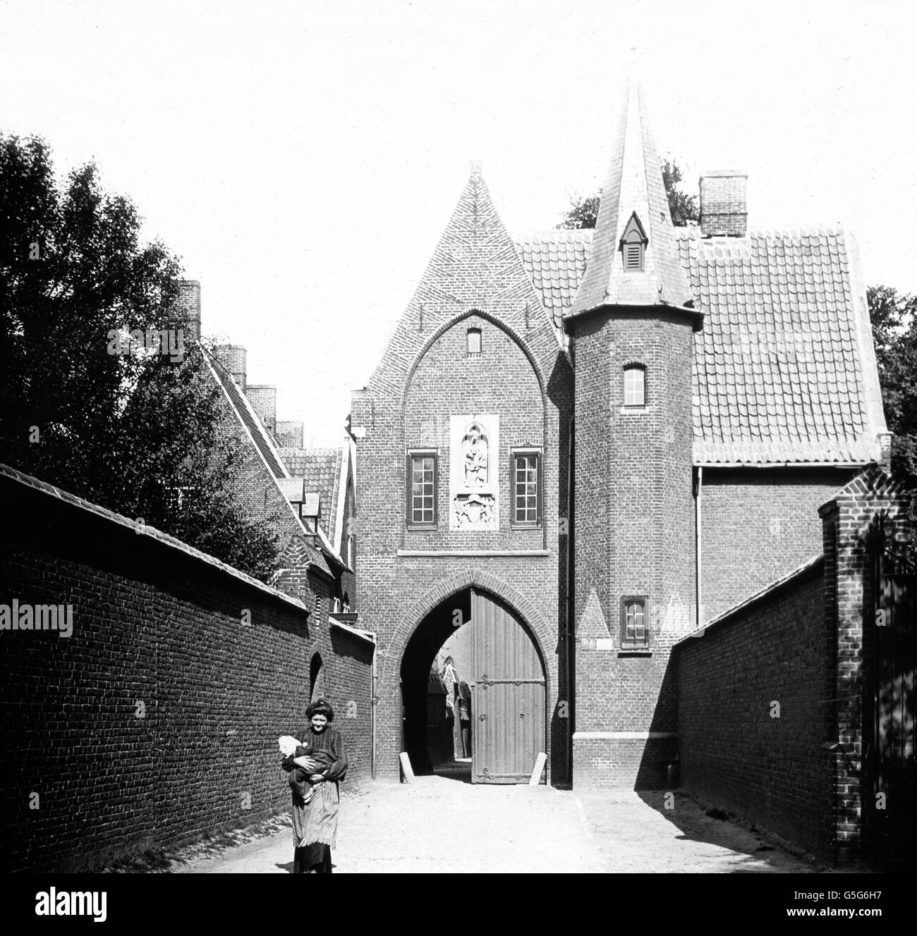 Gent, Eingang zum Beginenhof. The entrance to the Beguine quarter at Ghent in Belgium. Europe, Belgium, travel, history, historical, 1910s, 1920s, 20th century, archive, Carl Simon, entrance, court, nuns, religion, belief, black and white, women, baby, glass slide Stock Photo
