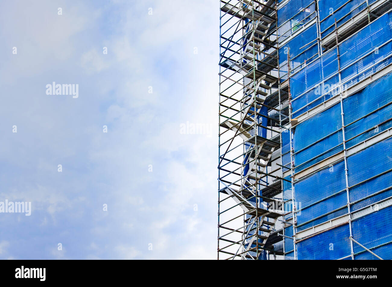 Safety mesh and scaffolding wrapped around a building as it rises into the sky in Australia. Construction site Stock Photo