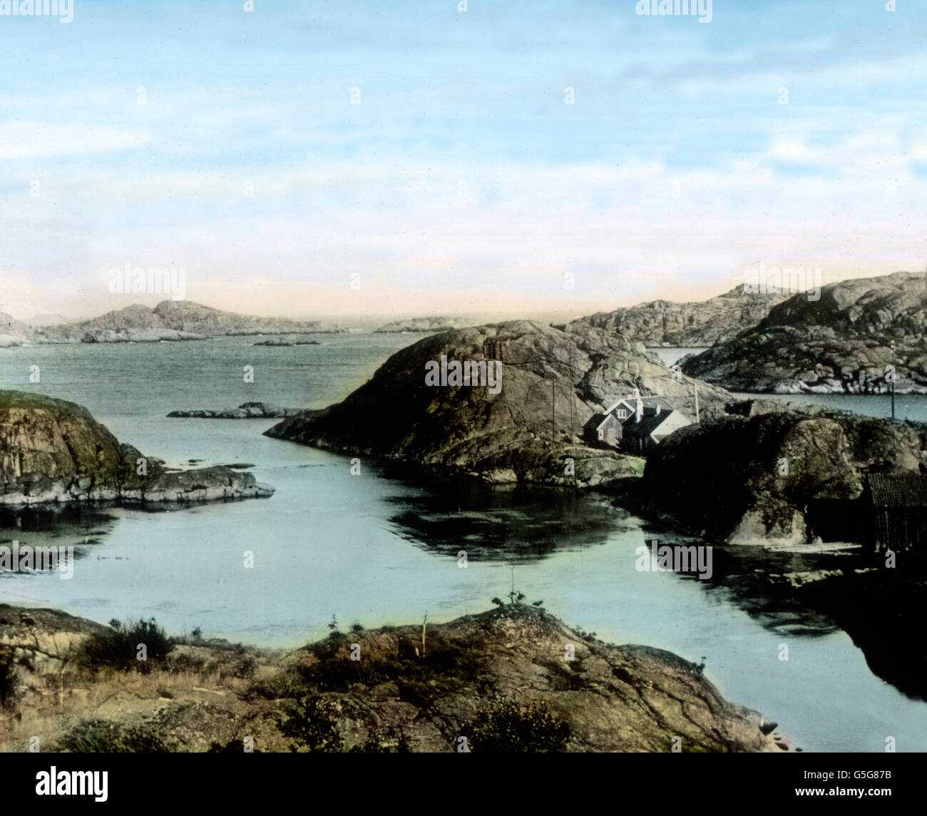 An der Küste von Norwegen. At the coast of Norway. shore, water, ocean, rocks, cost, coastal, islands, landscape, Europe, Norway, Scandinavia, travel, history, historical, 1910s, 1920s, 20th century, archive, Carl Simon, hand coloured glass slide Stock Photo