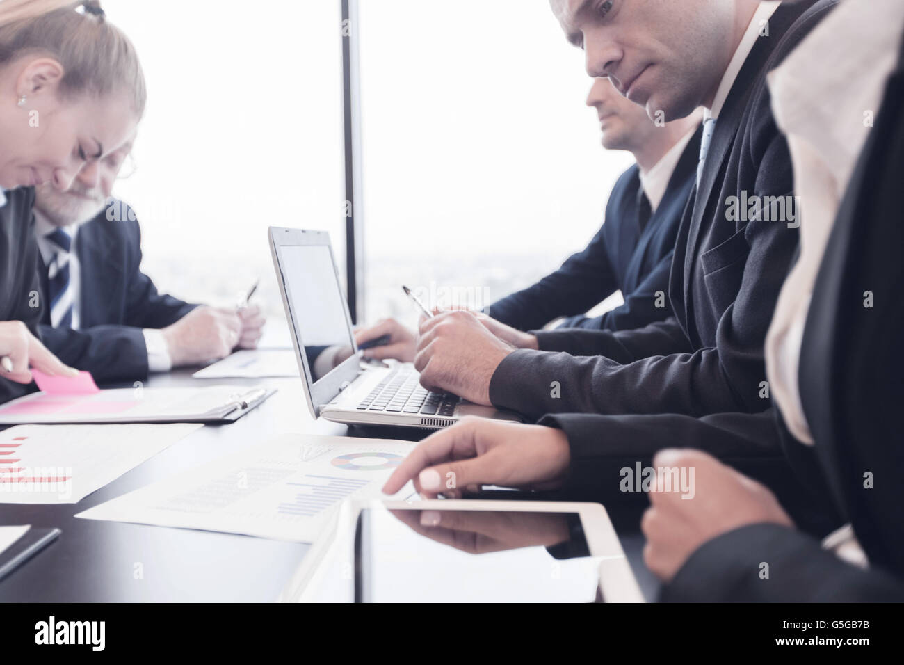 Business people analyzing financial figures of reports Stock Photo