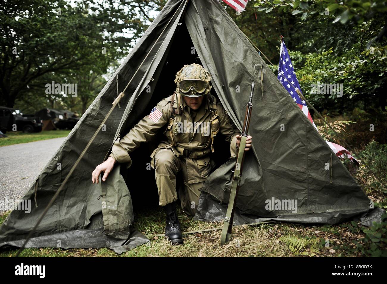 STANDALONE Photo. A man dressed as an American Army 101st Airborne soldier exits his tent clutching his replica M1 Garand rifle at the WWII Weekend at Castle Drogo in Devon. Stock Photo