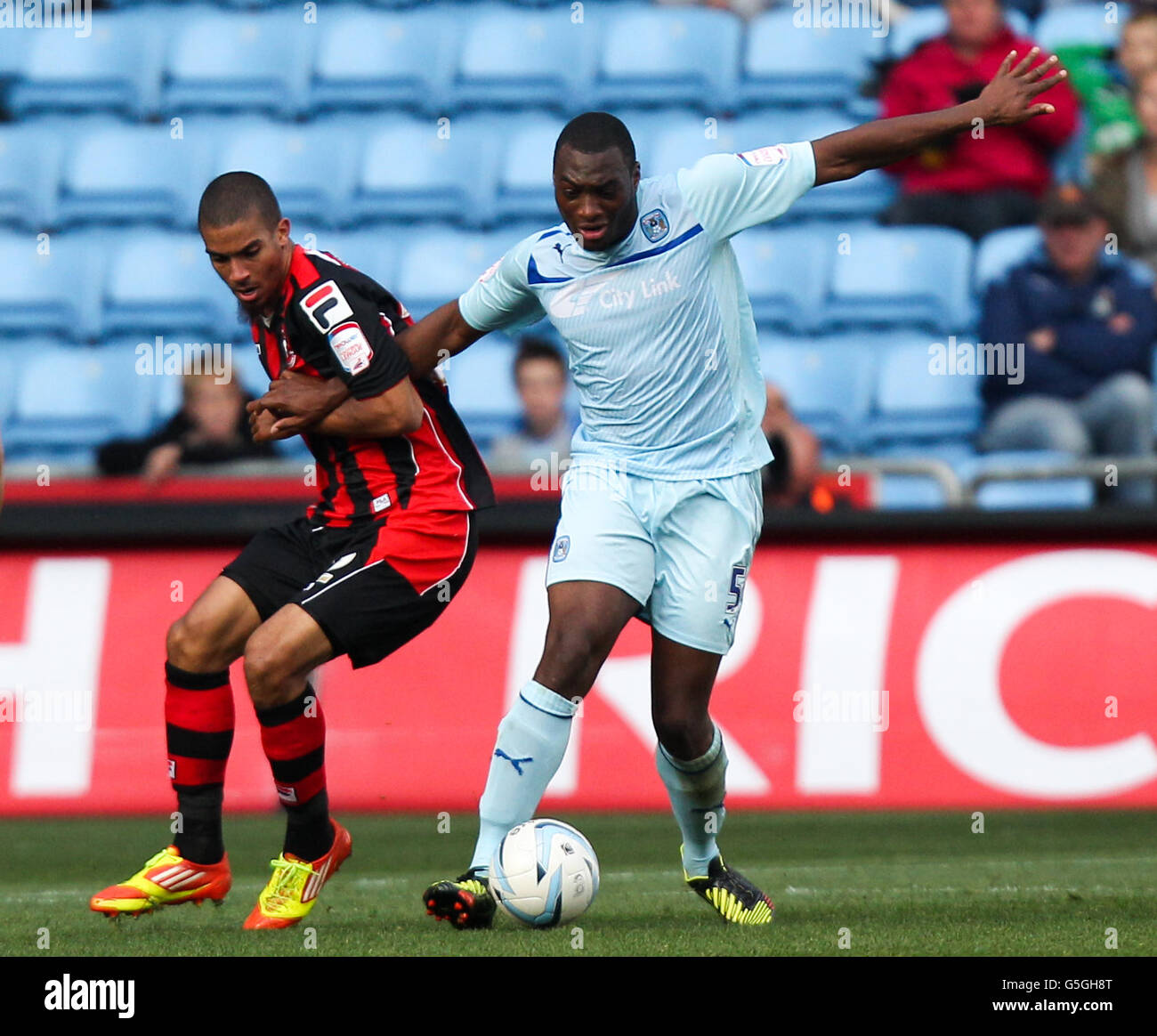 Coventry City's Nathan Cameron holds off the challenge of Bournemouth's Lewis Grabban during the npower Football League One match at the Ricoh Arena, Coventry. Stock Photo