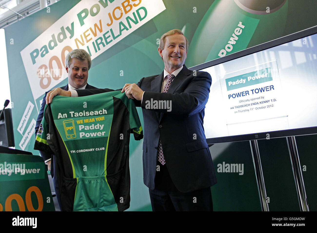 Taoiseach Enda Kenny is presented with a Paddy Power cycling jersey by Patrick Kennedy CEO at the official opening of Power Tower, the company's new headquarters for the bookmaker Paddy Power in Clonskeagh, Dublin, where the company also announced the creation of 600 new jobs. Stock Photo