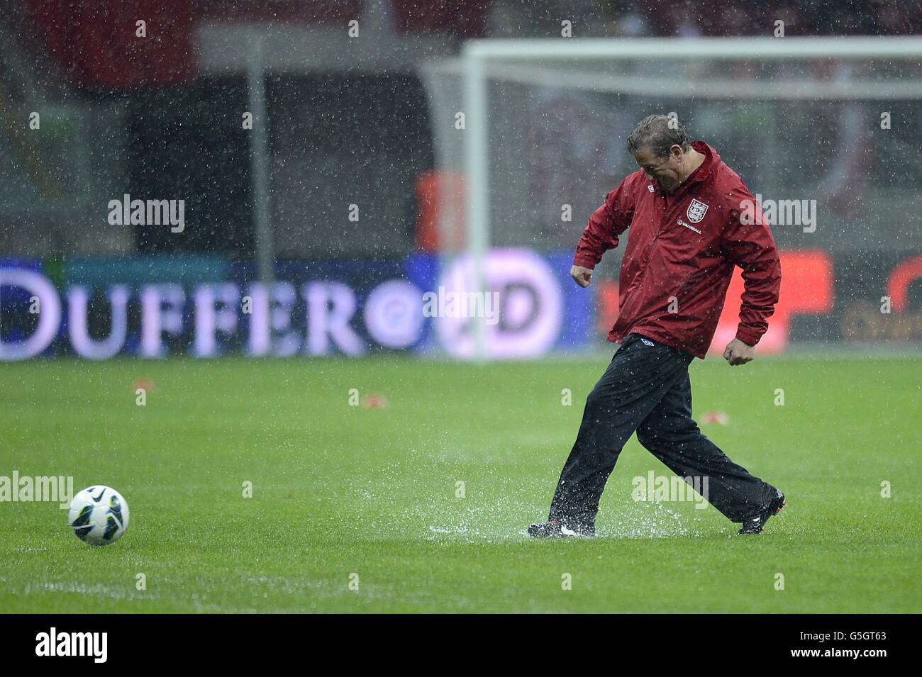 Soccer - 2014 FIFA World Cup - Qualifier - Group H - Poland v England - National Stadium. England manager Roy Hodgson tests the condition of the pitch in the pouring rain before the game Stock Photo