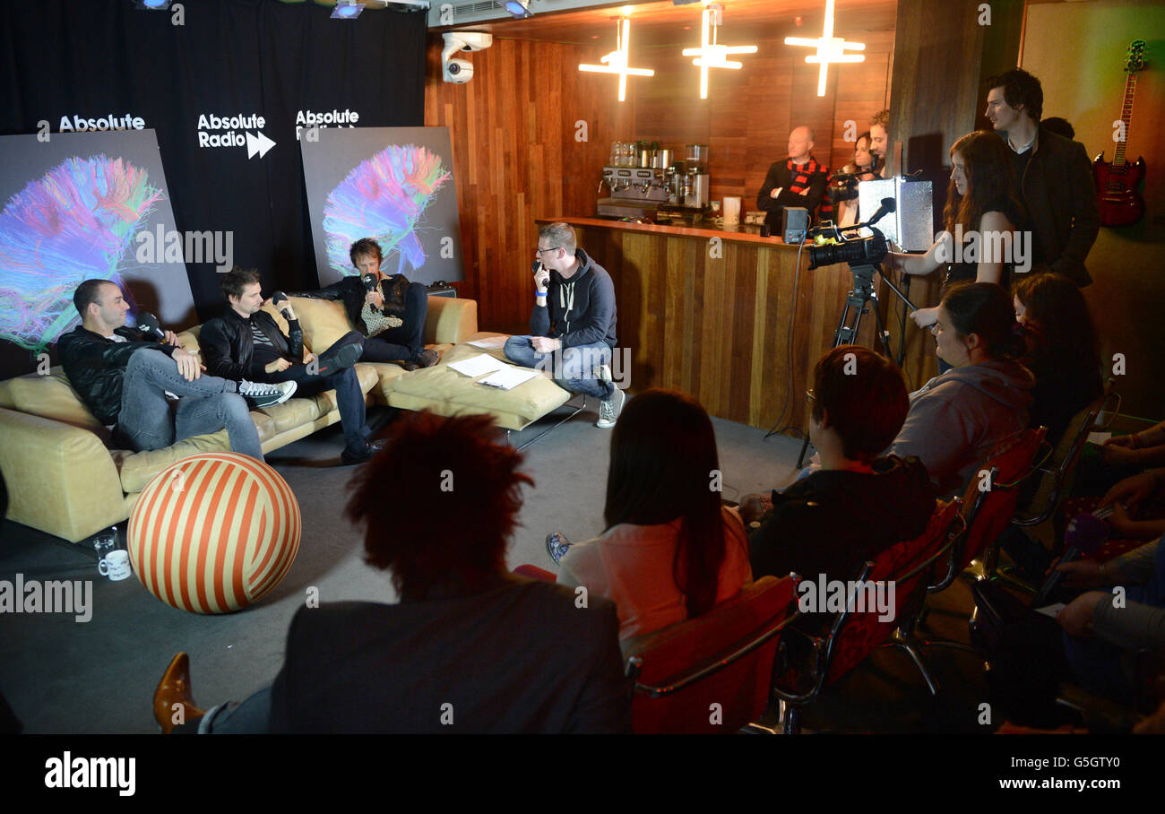 Muse take part in a Question and Answer session with DJ Andy Bush (facing,  4th left) and Absolute Radio listeners at the Absolute Radio studios in  central London Stock Photo - Alamy