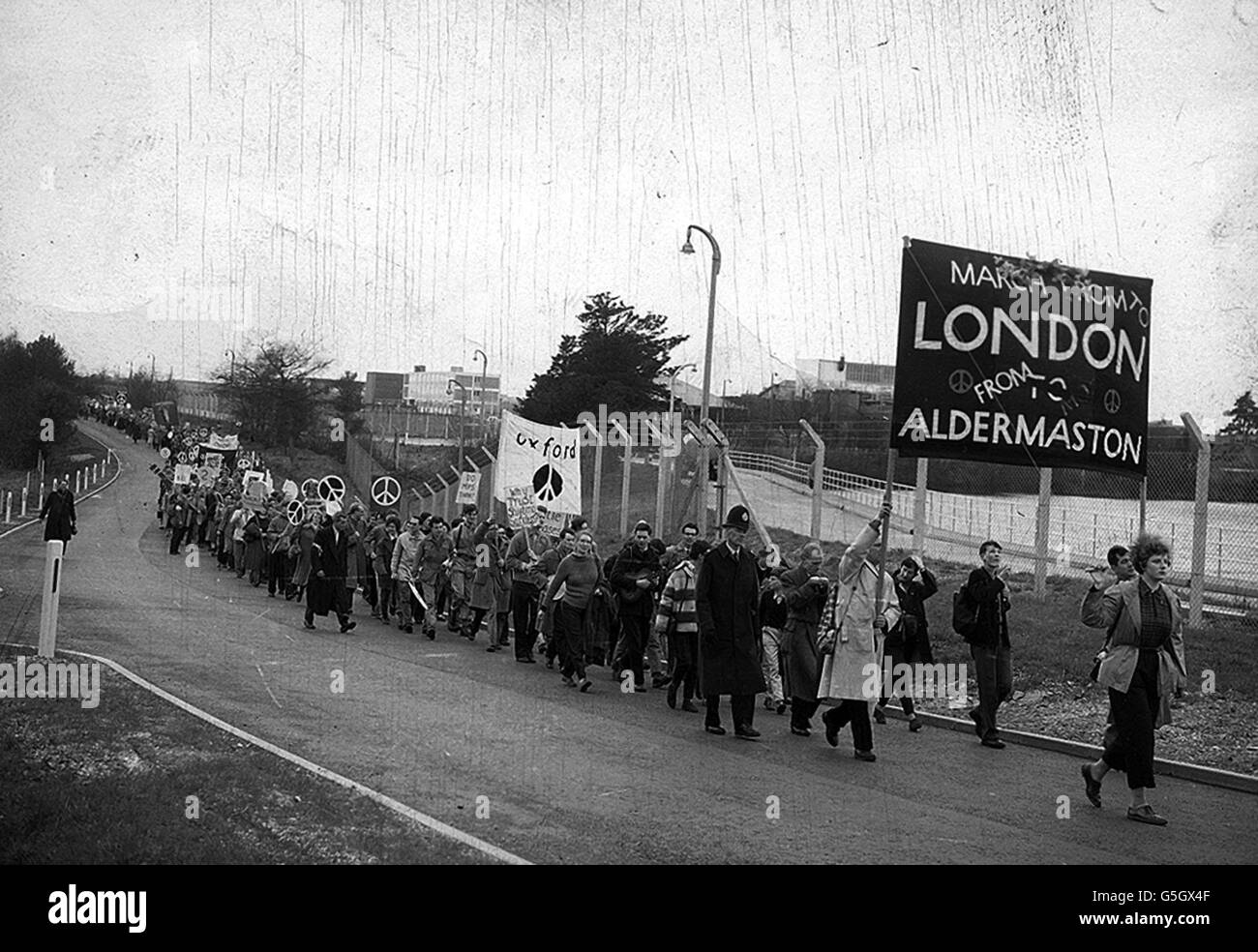 With a solitary policeman as escort, campaigners for nuclear disarmament begin their march from the Atomic Weapons Research Establishment at Aldermaston, Berkshire, to London. They face a 53 mile trek to Trafalgar Square. Stock Photo