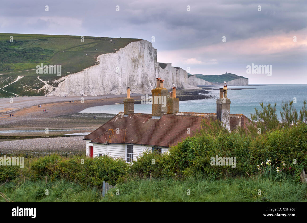 Coastguard cottages at Seaford Head above the Cuckmere River, with the Seven Sisters beyond. Sussex, England. Stock Photo