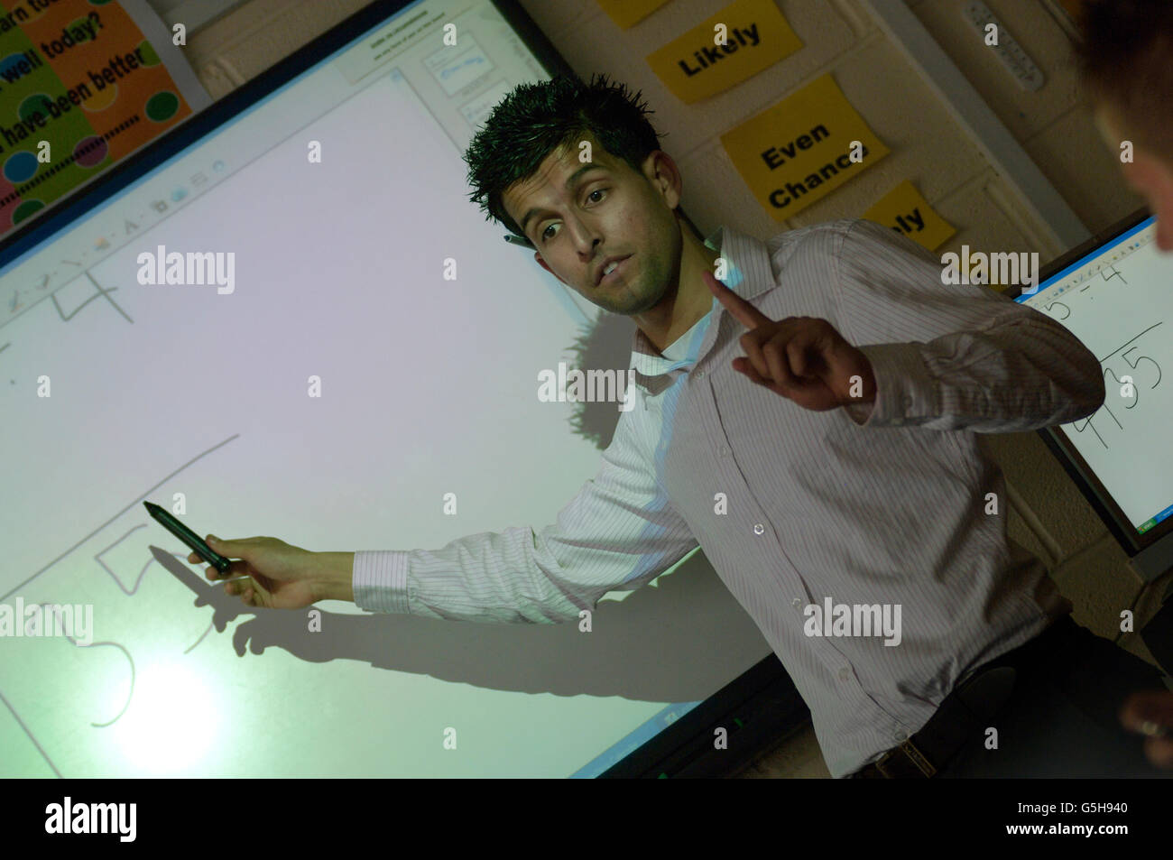 Secondary school maths teacher using an interactive whiteboard. England. UK Stock Photo