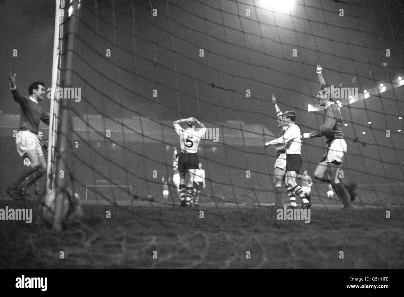 Manchester United's Denis Law (right) throws his hands in the air after scoring the team's second goal in their FA Cup sixth-round replay against Preston North End at Old Trafford. Other players pictured are Manchester United's John Connelly (left) and Preston North End's Anthony Singleton (with hands on head) and Nobby Lawton. Stock Photo