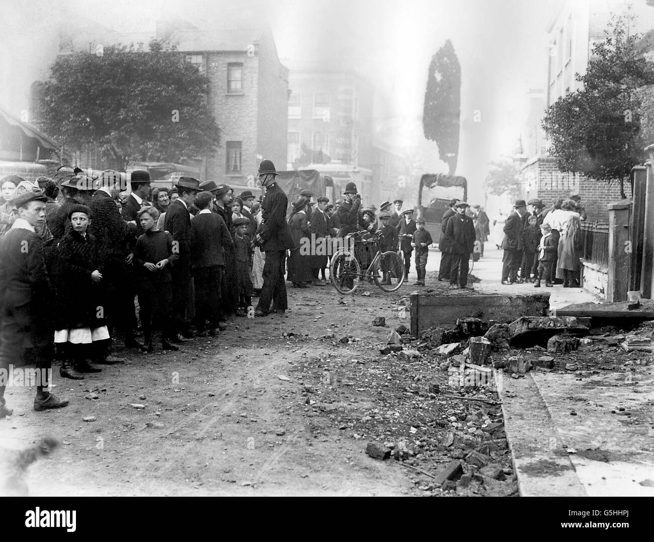 World War One - Zeppelin Raid on London. A crowd gather outside a bombed house. Stock Photo