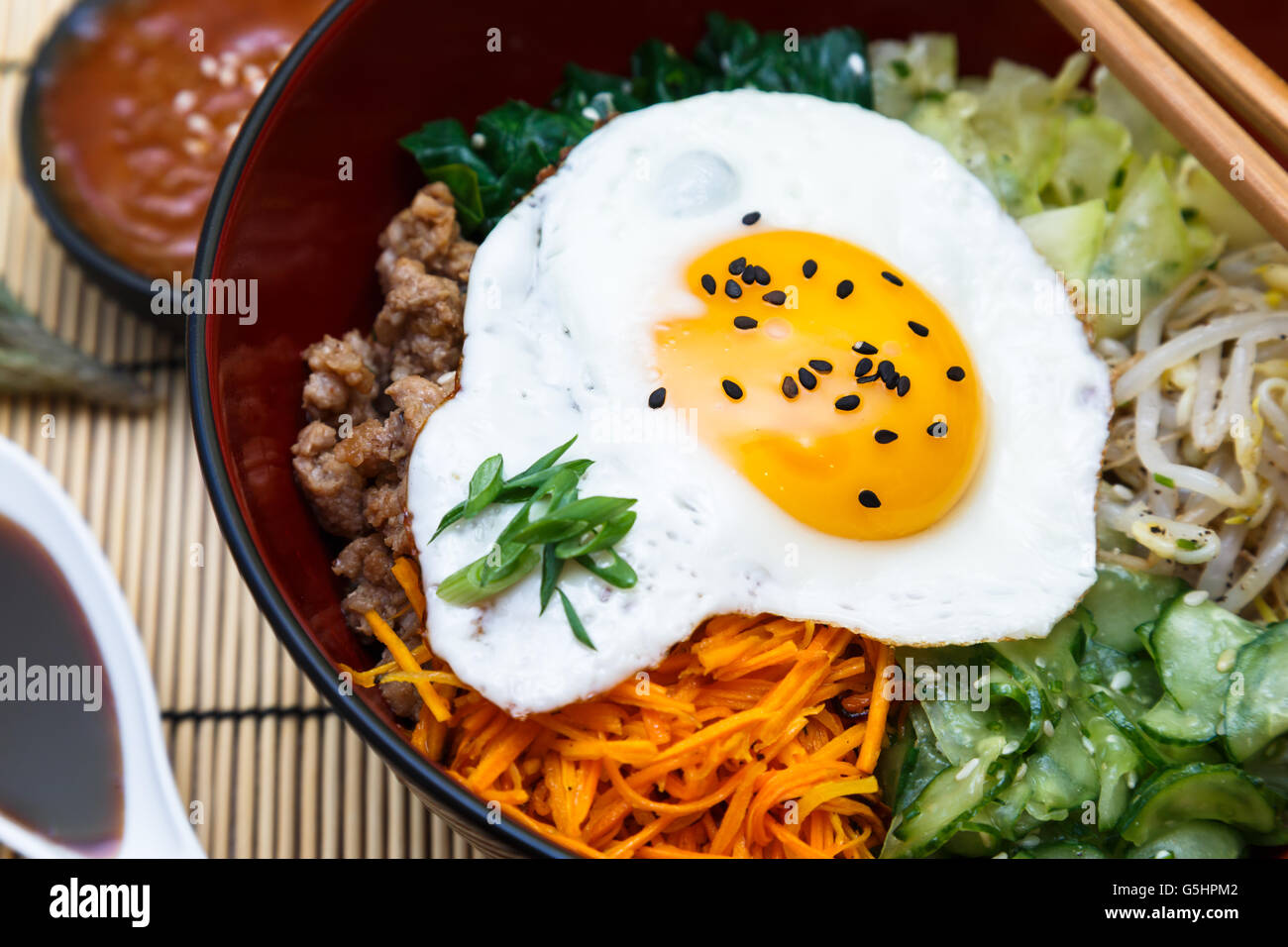 Korean cuisine, beef Bibimbap in a clay pot on wooden table Stock Photo
