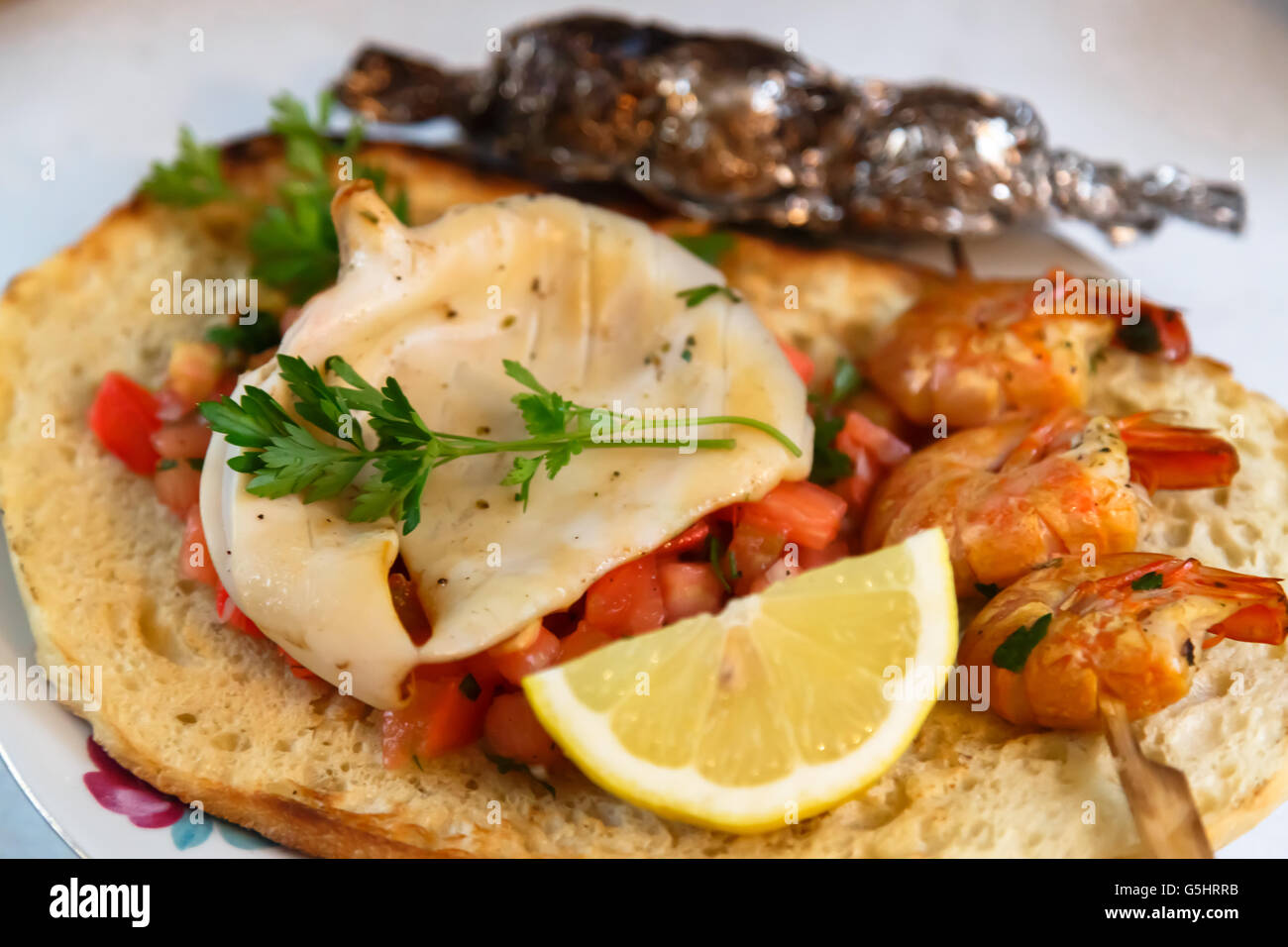 Grilled calamary and shrimps on Italian bruschetta Stock Photo