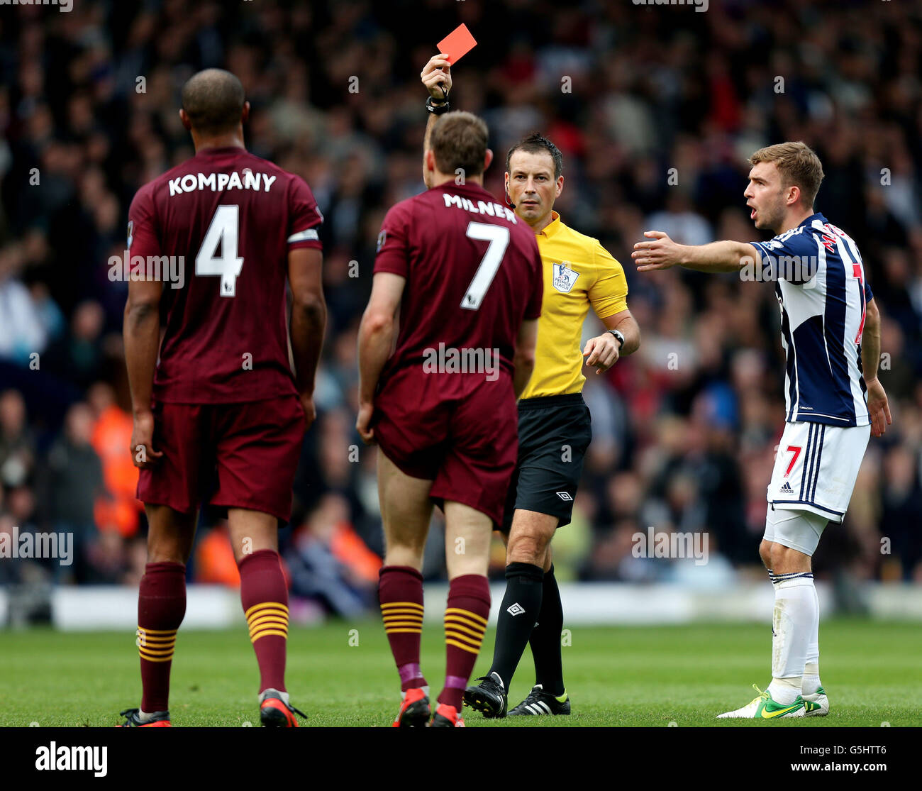 Referee Mark Clattenburg shows Manchester City's James Milner the red ...