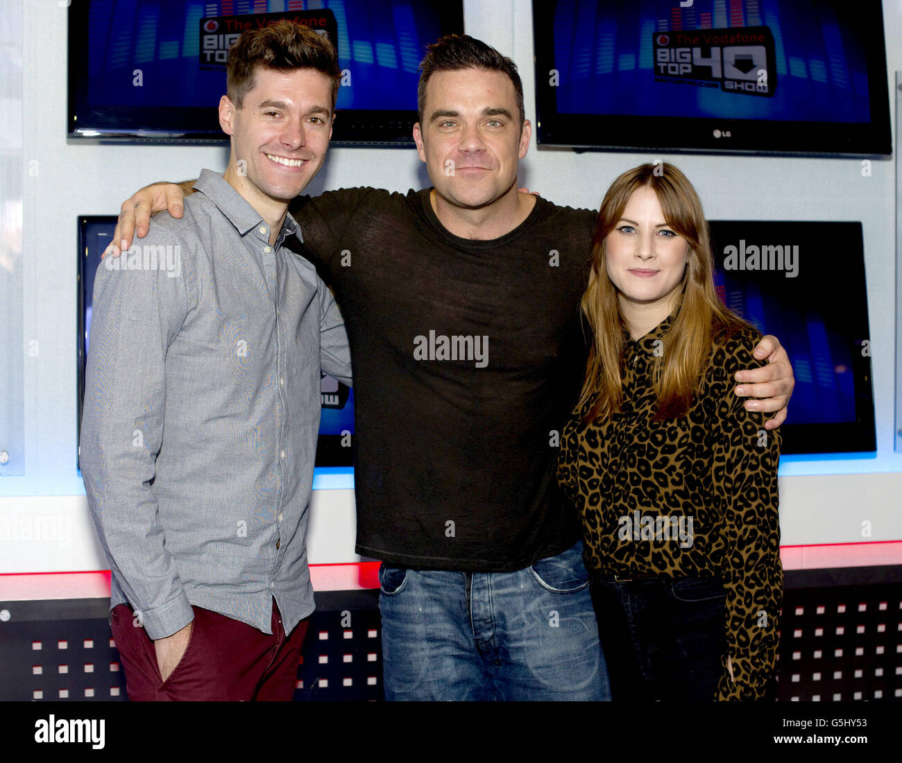 Robbie Williams pictured with Big Top 40 presenters Rich Clarke and Kat Shoob, during an interview at their studio in Leicester Square in London. Stock Photo