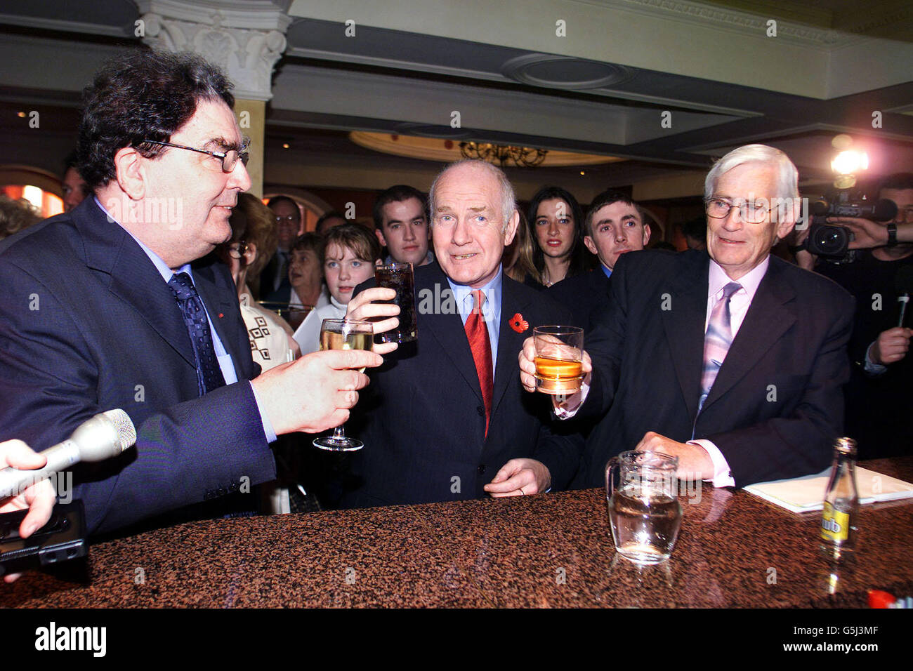 Northern Ireland Secretary of State John Reid (centre) buys John Hume and Seamus Mallon a farewell drink, before Hume's last speech as party leader at the Social Democratic Labour Party's annual conference in Newcastle, Co Down. Stock Photo