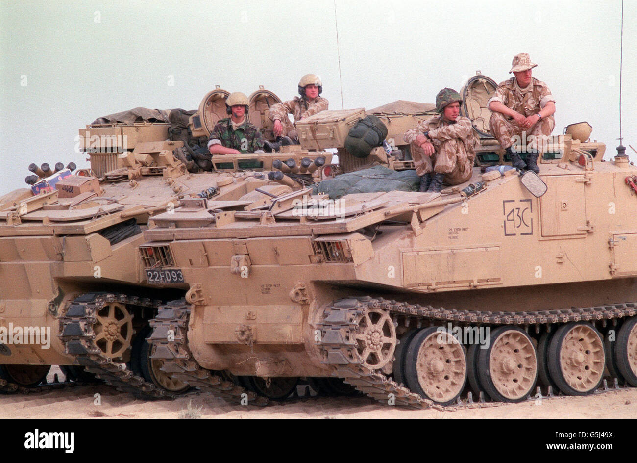 THE GULF WAR: Soldiers of the Royal Engineers of 1st Armoured Division take a break on their combat engine tractors, used for searching out land mines, in the Gulf. Stock Photo