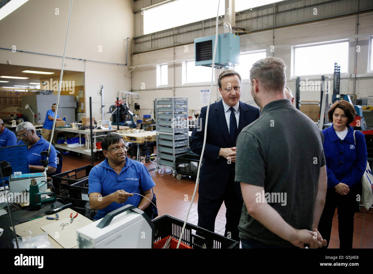 Prime Minister David Cameron speaks to employees as Jane Ellison looks on during an EU referendum related visit to Panorama Antennas, a small family business in Wandsworth, south London. Stock Photo