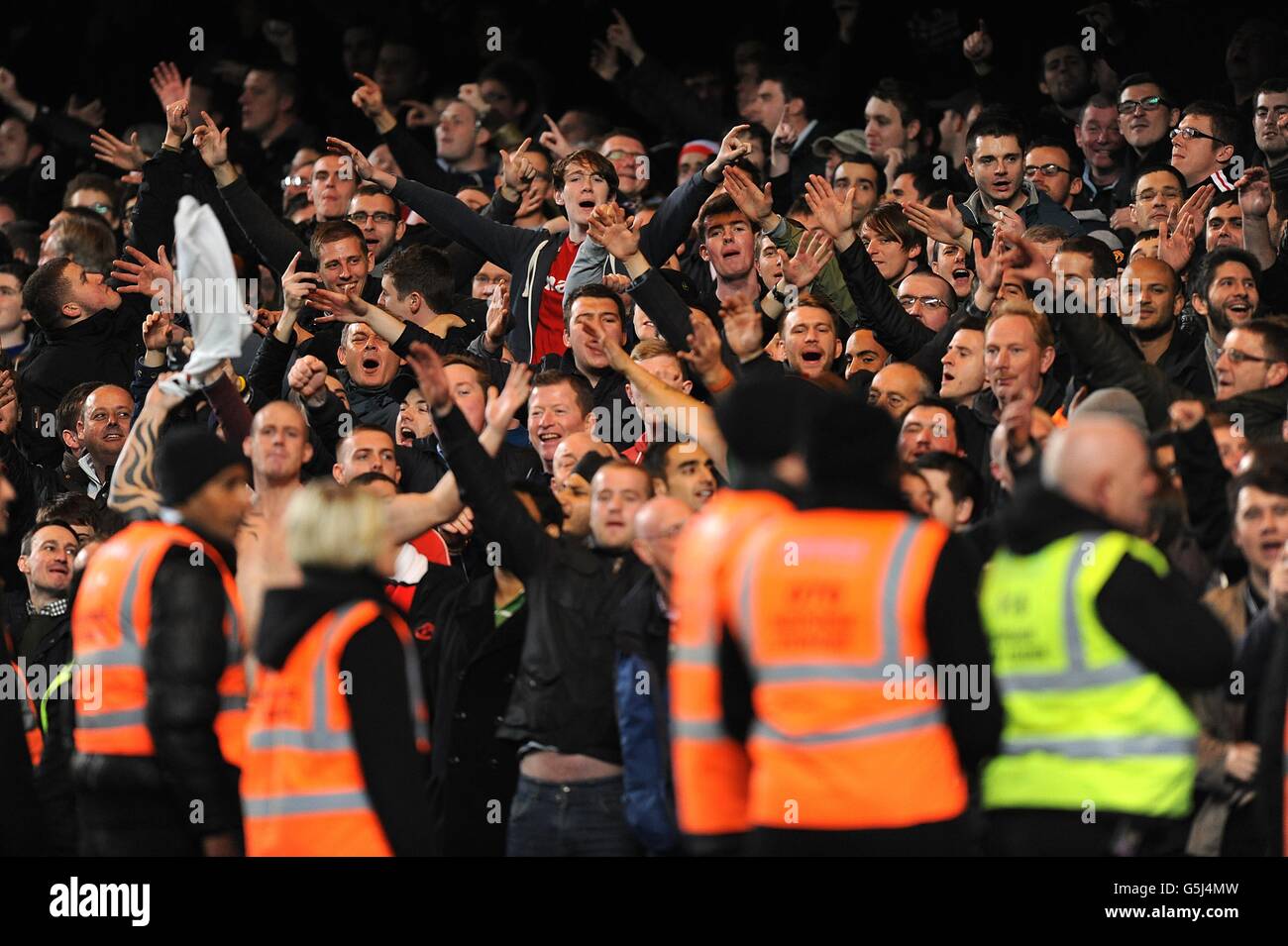 Manchester United fans cheer on their side in the stands Stock Photo