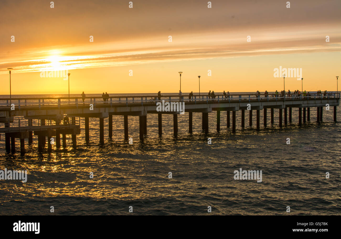 PALANGA LITHUANIA - JUNE 13: Sunset view at the Palanga wooden dock. Palanga is the most popular summer resort in Lithuania Stock Photo