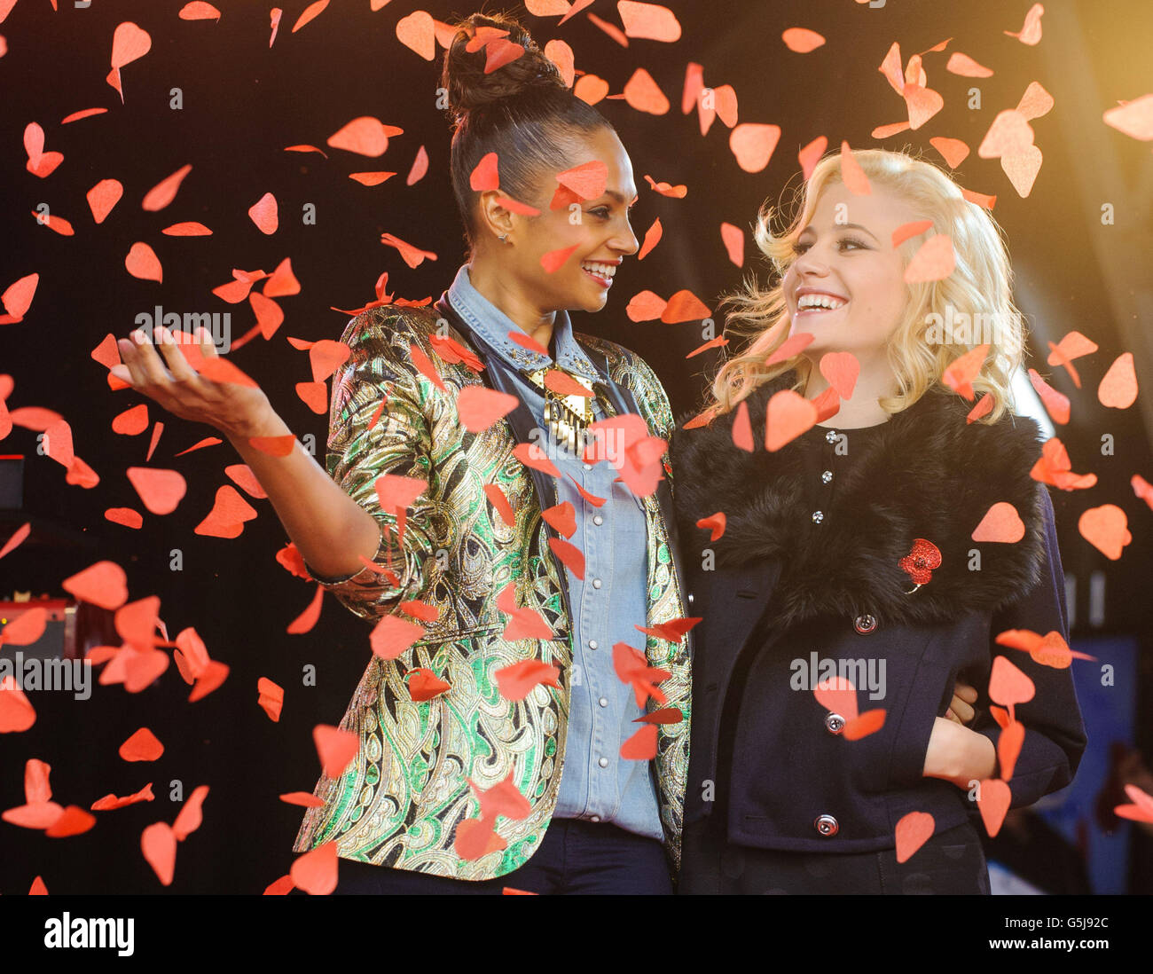 Alesha Dixon (left) and Pixie Lott are showered with poppy petals at the launch of the Royal British Legion Poppy Appeal 2012, in Trafalgar Square, central London. Stock Photo