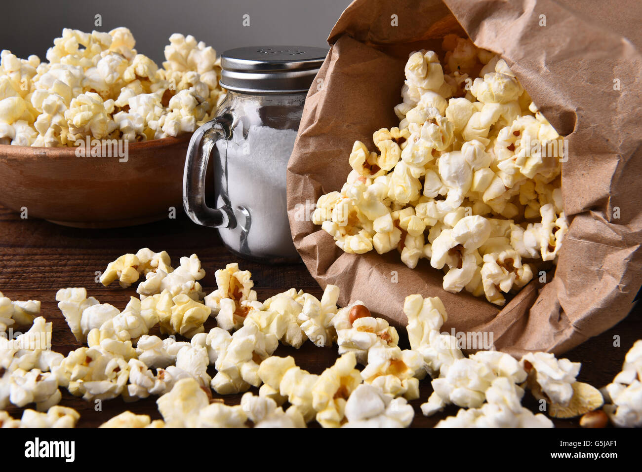 Closeup of a bag of fresh popped popcorn with a bow and salt shaker