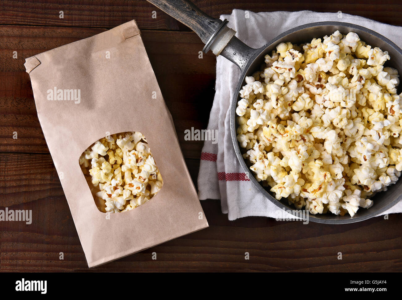 Top view of a bag of gourmet popcorn next to a pot of freshly popped corn. Stock Photo