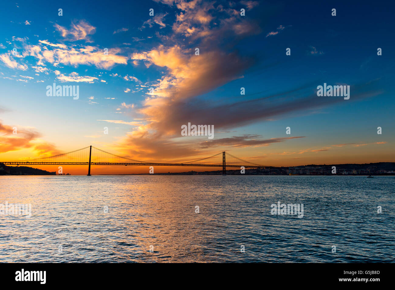 View of the bridge over the Tagus River in Lisbon, Portugal, at sunset Stock Photo