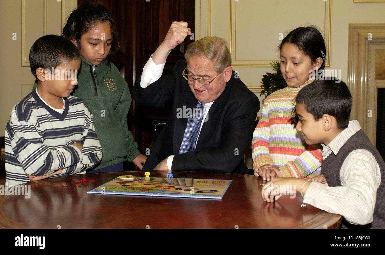 Governor of the Bank of England, Sir Edward George, supports 'Open for Business Week' by playing a board game aimed at improving numeracy with 8 year-olds (from left) Shah Nahid, Sharia Banu,Tasnim Khanam and Jamil Ahmed from Osmani Primary School. * .... Whitechapel, London. Open for Business Week is organised by the London Education Business Partnership which encourages businesses to volunteer time and resources to schools. Stock Photo