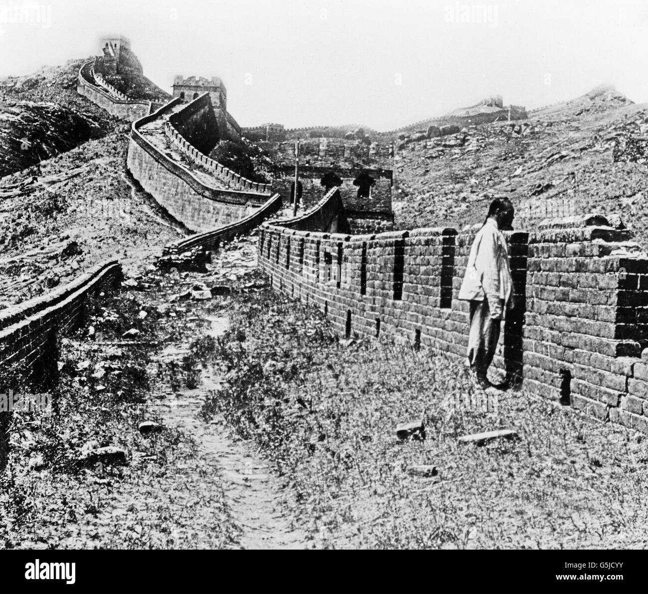 Ein Chinese steht an der chinesischen Mauer, China 1910er Jahre. A Chinese standing at the Chinese Wall, China 1910s. Stock Photo