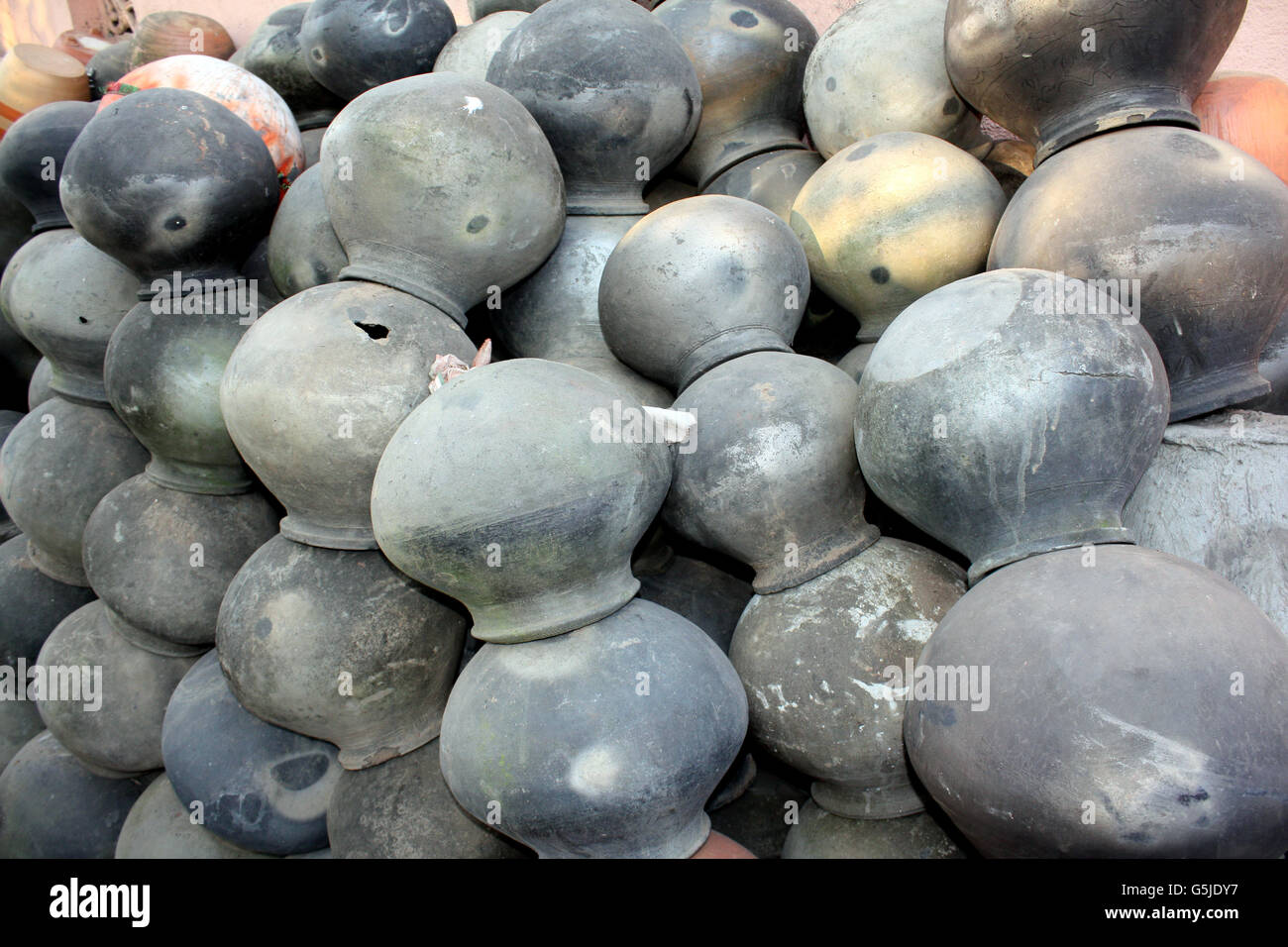 A background of clay pots used for keeping water cool, a traditional