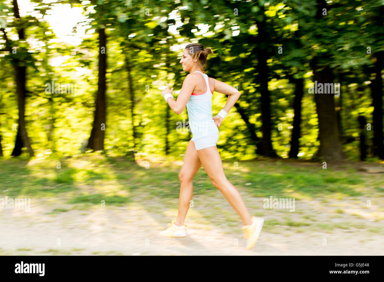 Beautiful Girl Jogging In The Park. Looking At Camera. Stock Photo