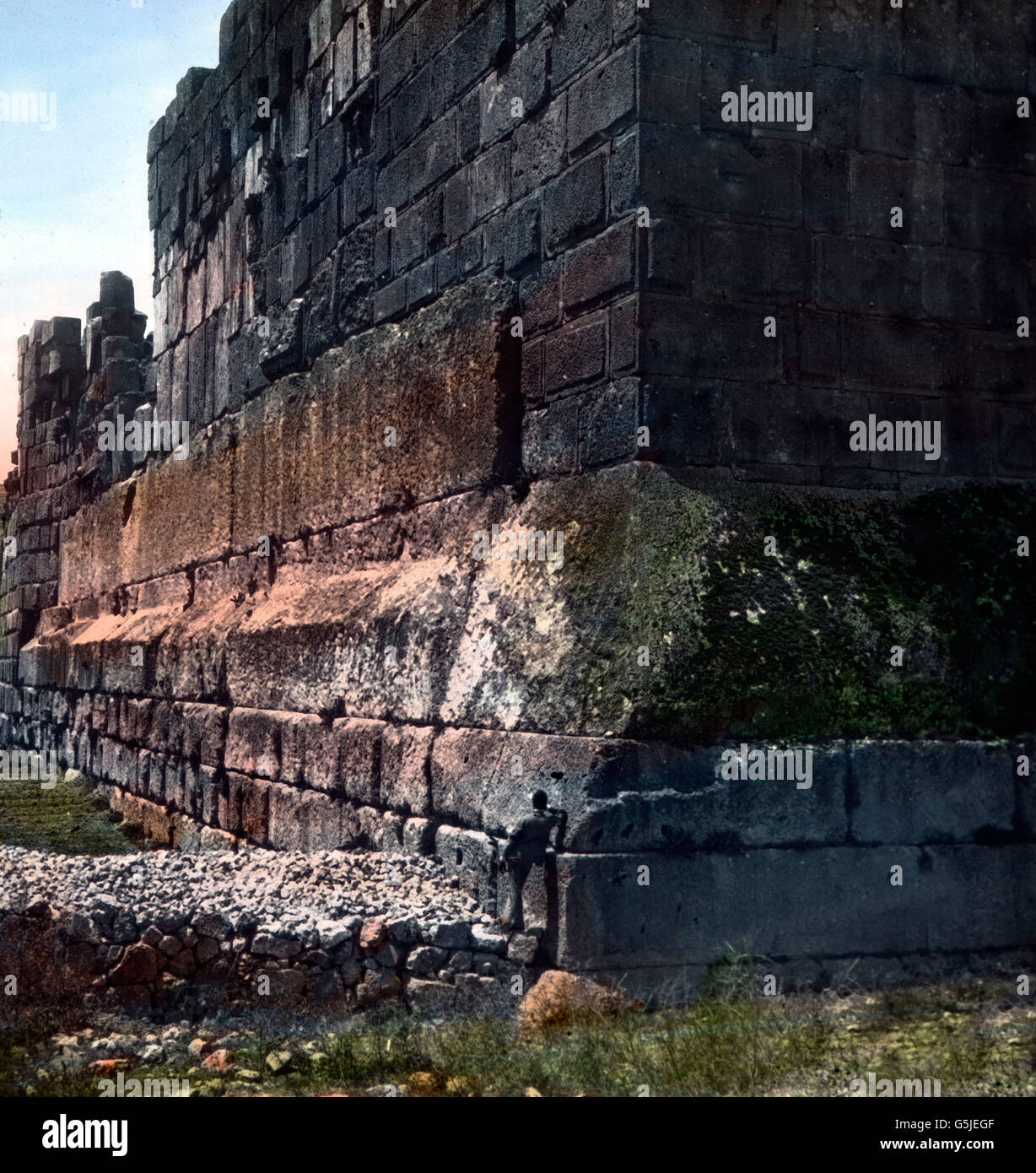 Ein Mensch lehnt als Größenvergleich an der Zyklopenmauer des alten Baalbek im Libanon, 1920er Jahre. A man leaning at the Cyclop's wall of ancient Baalbek in the Lebanon, 1920s. Stock Photo