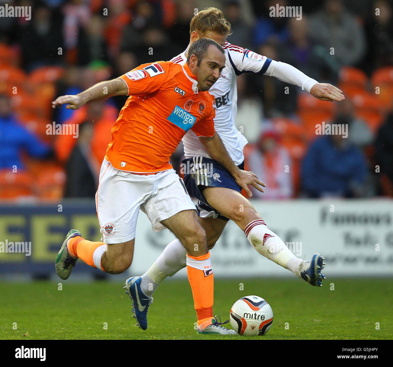 Blackpool's Gary Taylor-Fletcher and Bolton's Matt Mills during the npower Football League Championship match at Bloomfield Road, Blackpool. Stock Photo