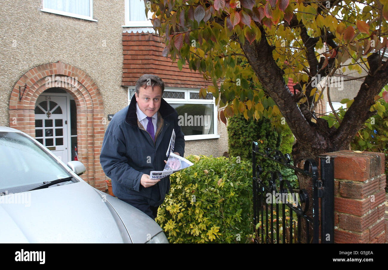 Prime Minister David Cameron helps deliver election leaflets to support Ken Maddock, Avon and Somerset Police and Crime Commissioner candidate for the Conservative party, in a residential street in the Downend area of Bristol, England. Stock Photo