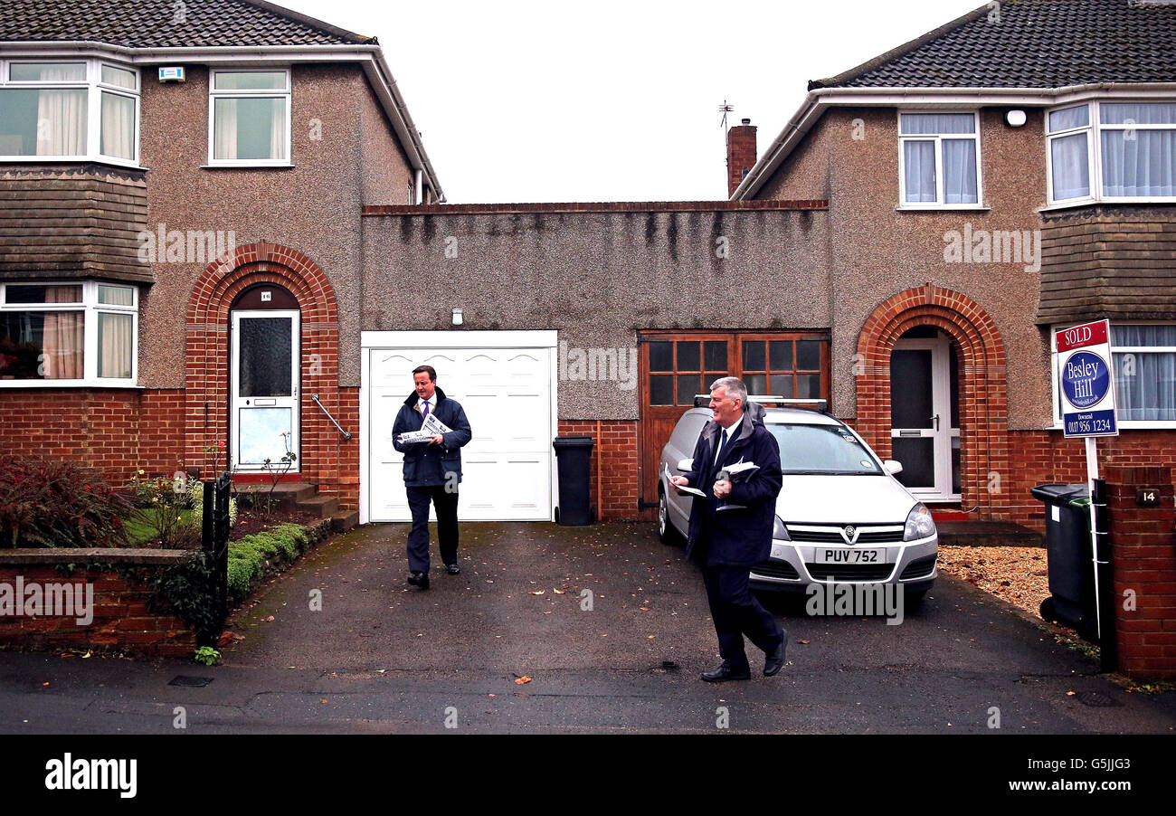 Prime Minister David Cameron (L) helps (R) Ken Maddock, Avon and Somerset Police and Crime Commissioner candidate for the Conservative party, deliver leaflets in a residential street in the Downend area of Bristol, England. Stock Photo