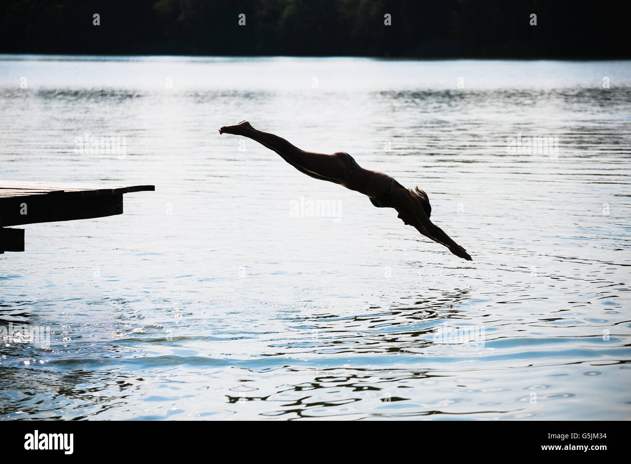 woman jumping into the lake Stock Photo