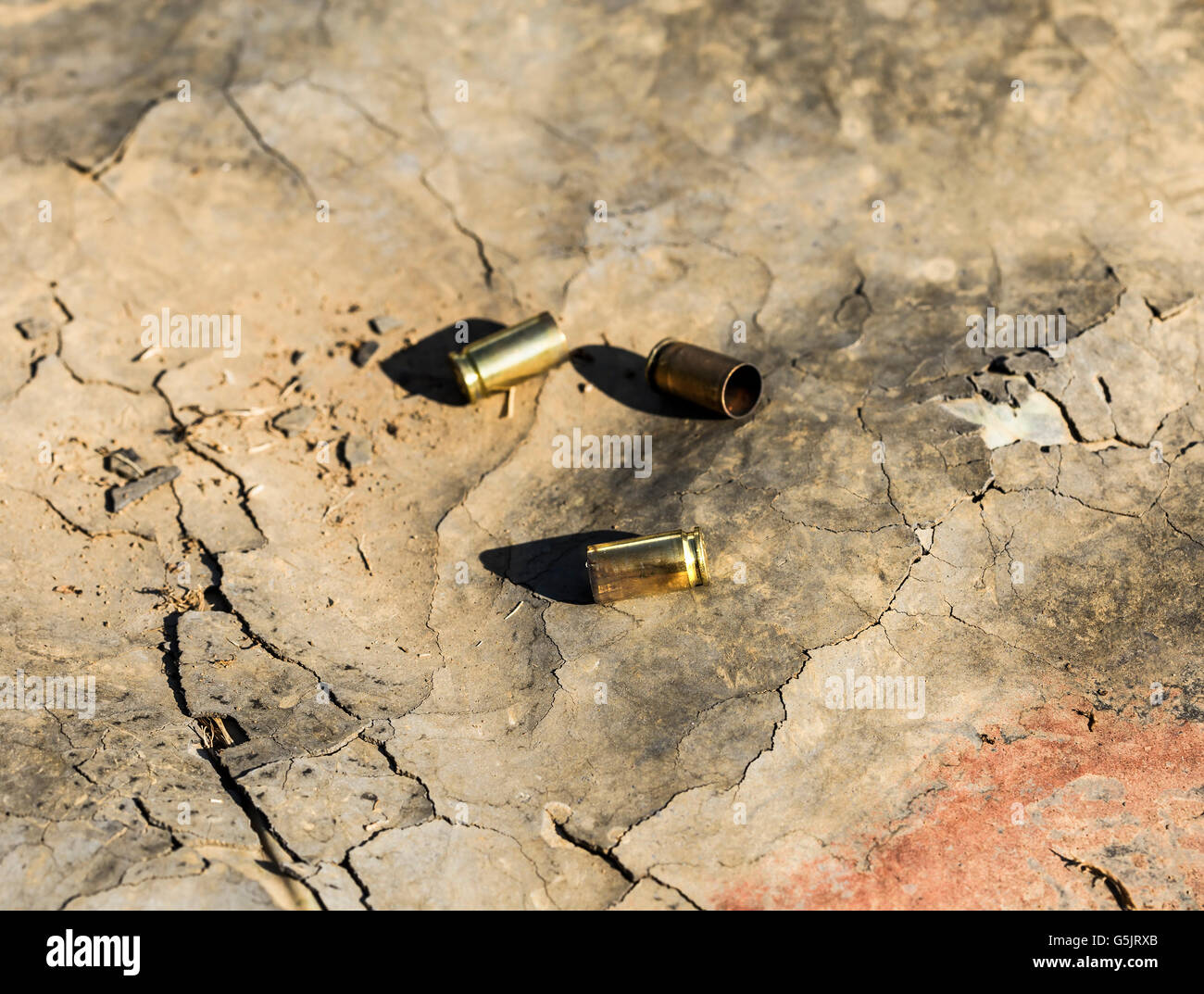Used bullets laying down on the ground. Stock Photo