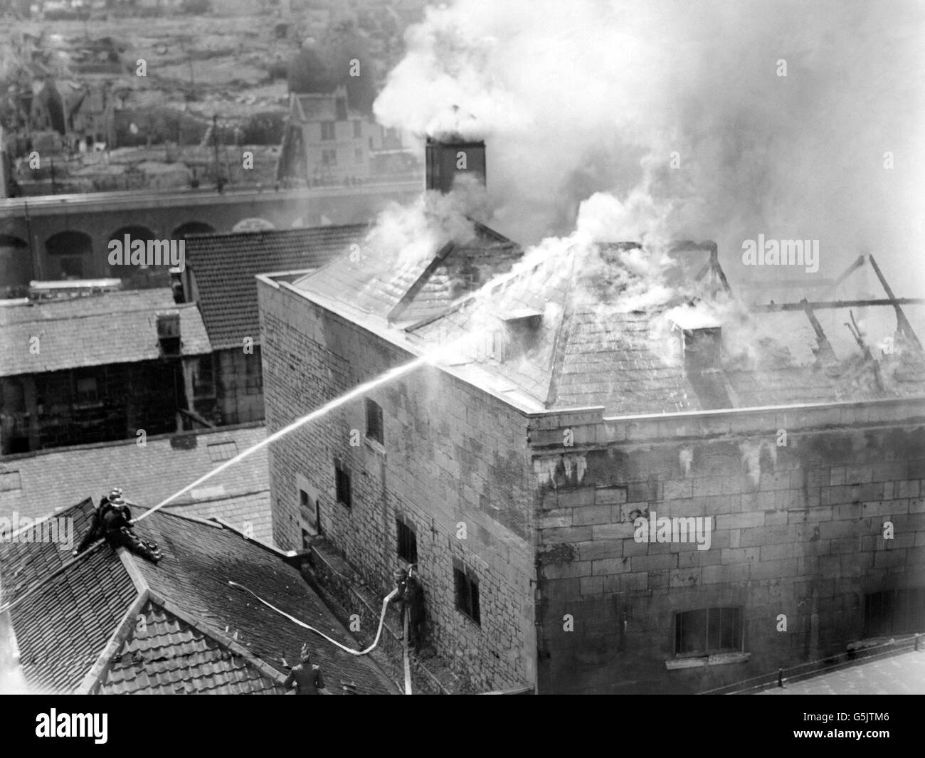 Firemen direct hoses onto the burning roof of the malt house at M Tuckers and Sons, in Bath, Somerset. Stock Photo