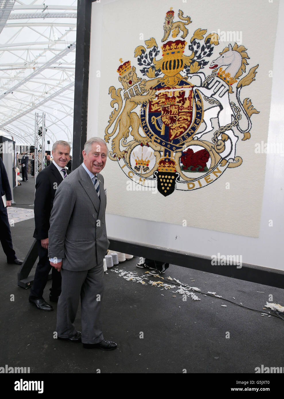 The Prince of Wales looks at a wool carpet featuring the royal crest at a New Zealand Sheer Brilliance event in the Cloud in Auckland, New Zealand. Stock Photo