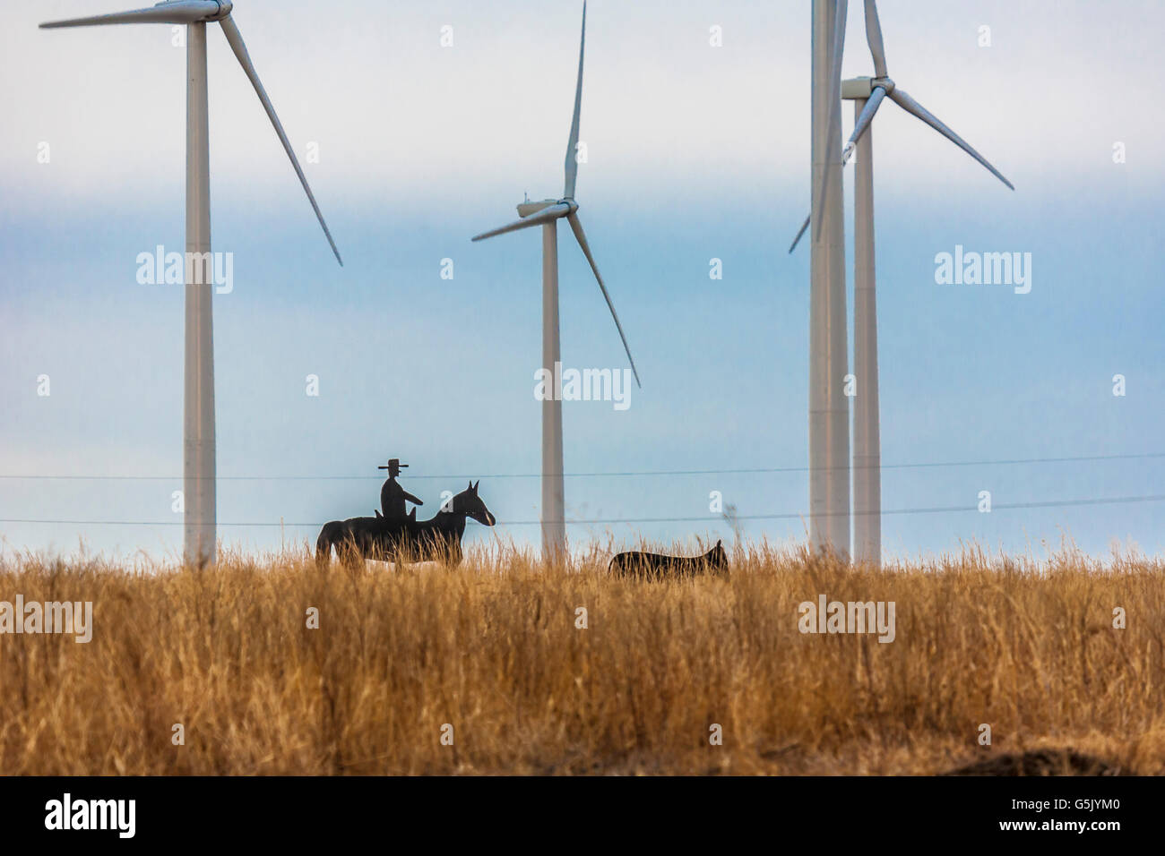 Cutouts of cowboy and cow at wind farm with wind turbine generators in rural north eastern Nebraska Stock Photo
