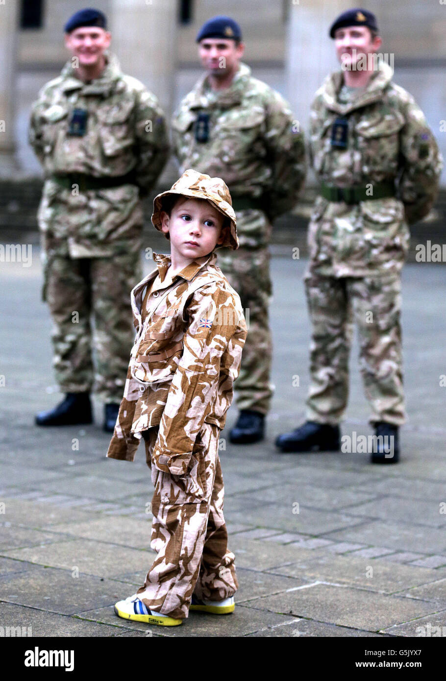 Kyle McClemments, aged four, from Dundee with Soldiers from the 19th Regiment Royal Artillery (The Highland Gunners) during a homecoming parade in Dundee to mark their return from Afghanistan. Stock Photo