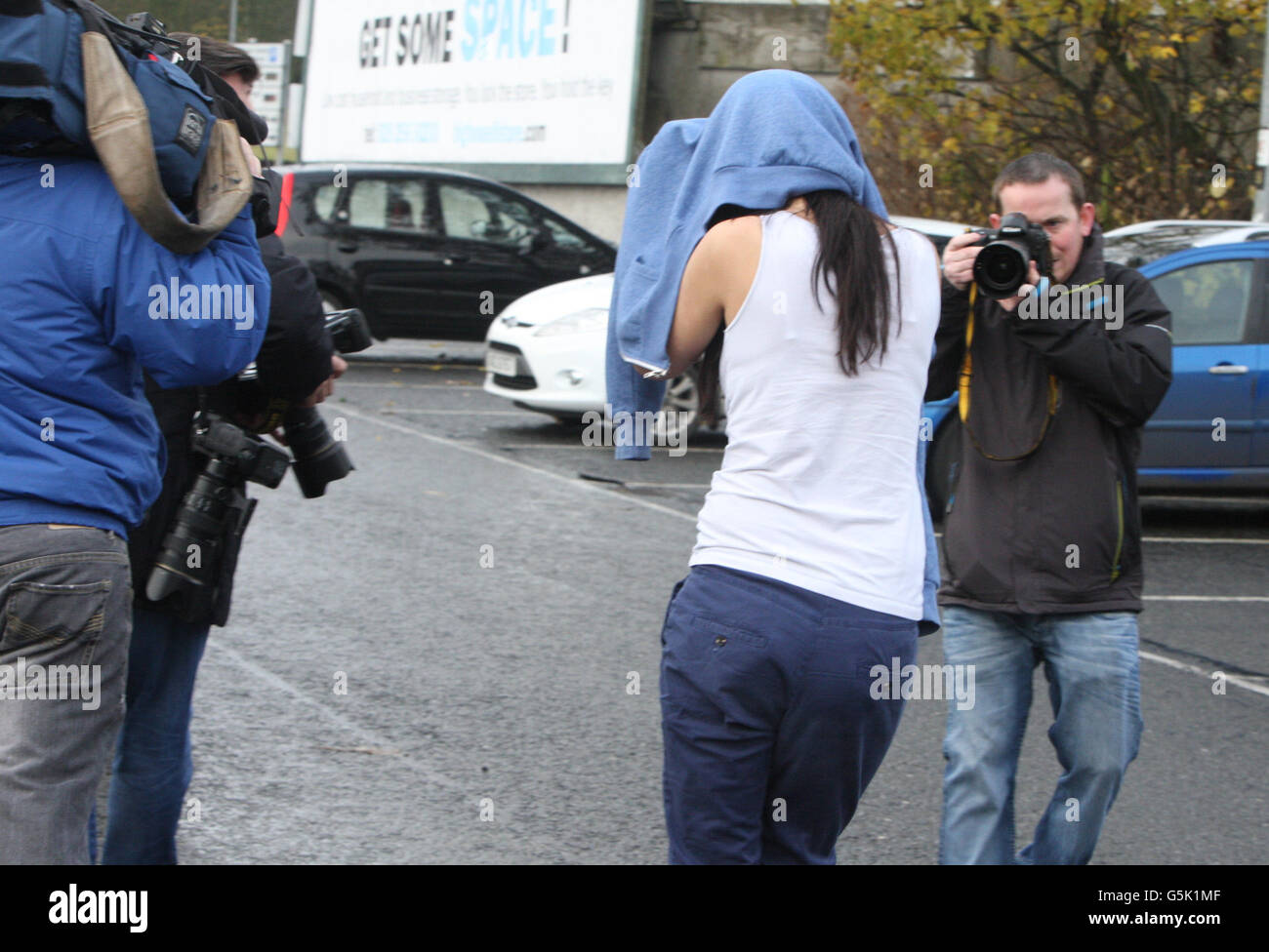 Jennifer Toland, 23, hides her face as she leaves Ballymena Magistrates' Court after she was released on bail after being charged with the manslaughter of pensioner Bertie Acheson. Stock Photo