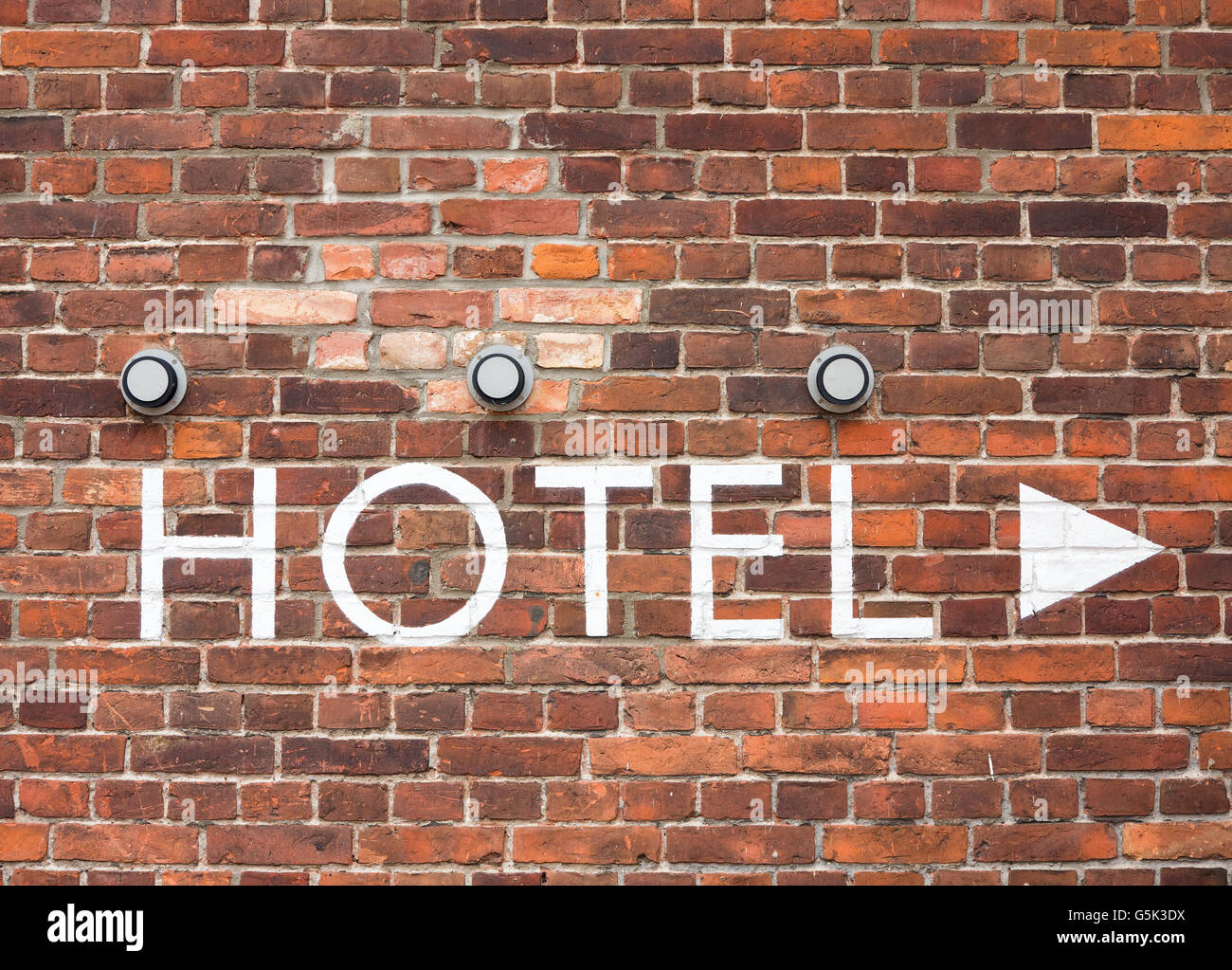 Hotel letters on a brick wall with arrow Stock Photo - Alamy