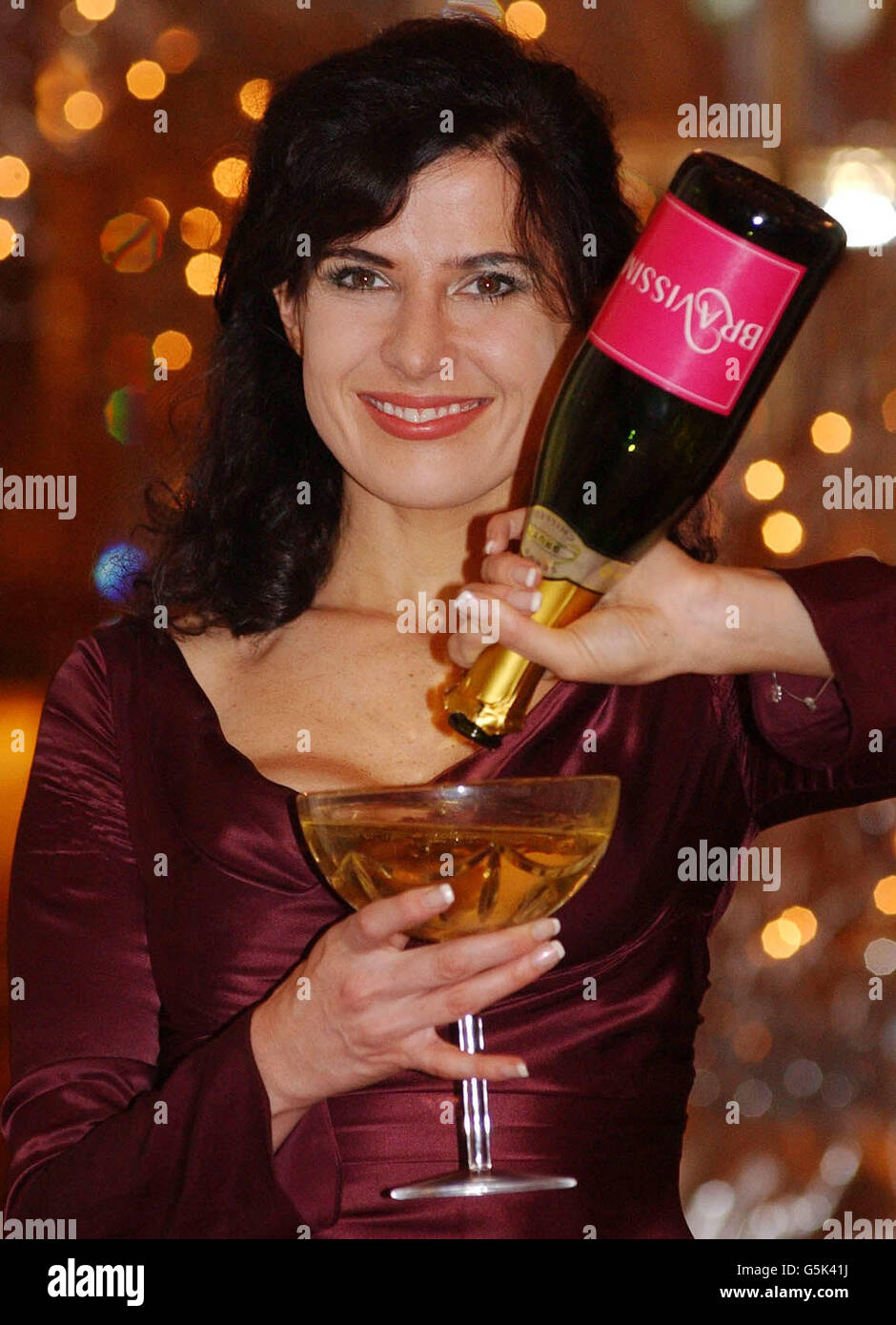 Comedienne Ronni Ancona unveils the new more voluptuous champagne glass (left) commissioned by Langerie manufacturers Bravissimo and made by Waterford Crystal, to celebrate modern women's larger chest sizes, at the Ritz, London. * The traditional 200ml champagne glass (right) is reputed to have been based on Marie Antoinette's modest decolletage (who's bust is pictured with the comedienne) with the new 550ml glass refecting the larger chest size of modern women. Stock Photo