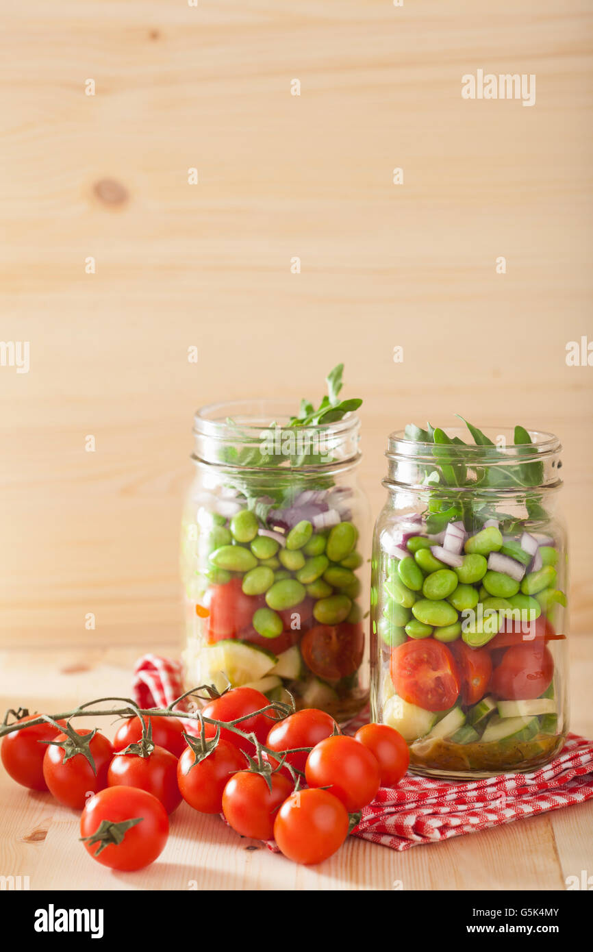 healthy vegetable salad in mason jar tomato, cucumber, soybean, onion