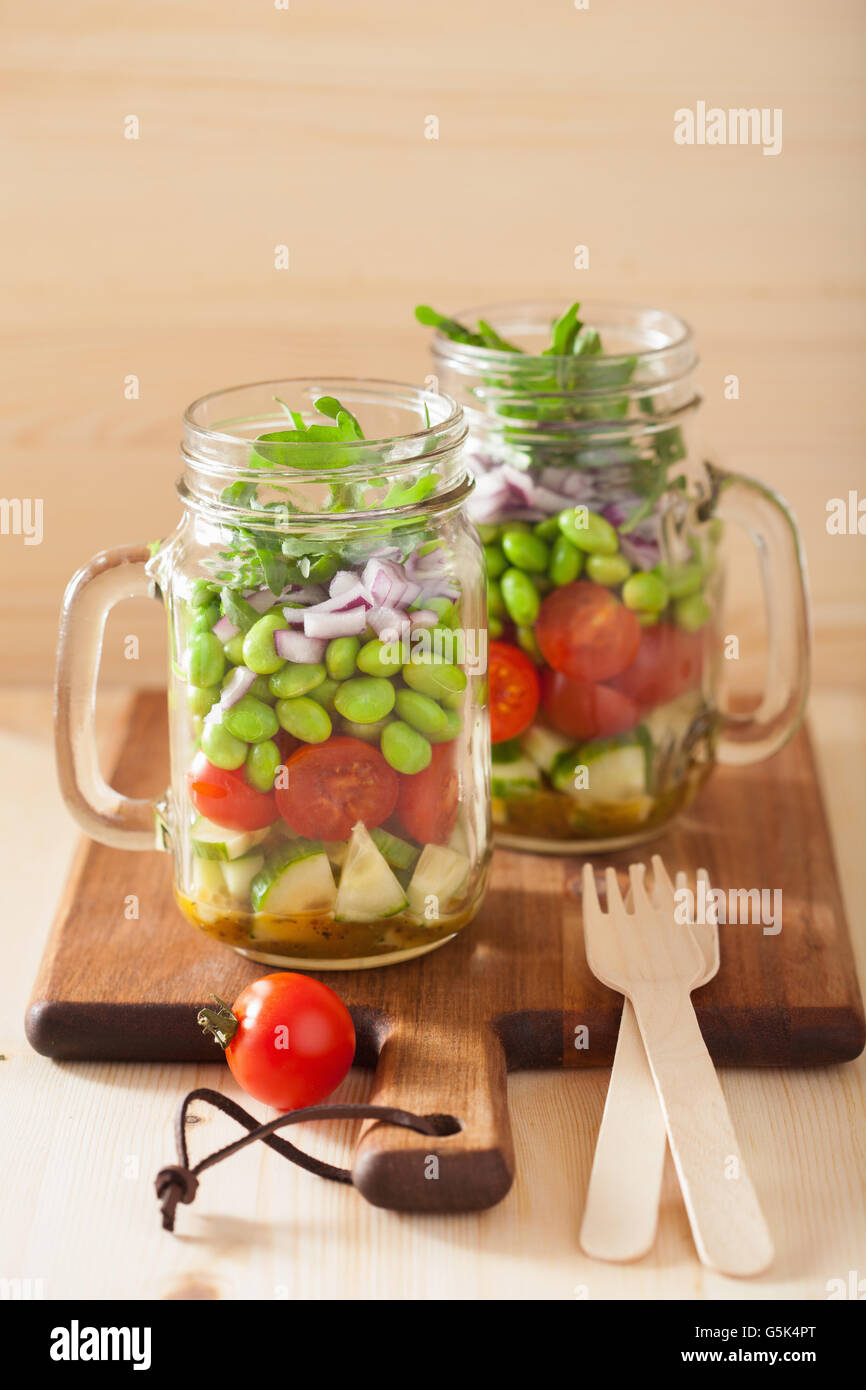 healthy vegetable salad in mason jar tomato, cucumber, soybean, onion